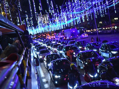 Varios pasajeros observan las luces desde el autobús descapotable en Madrid.