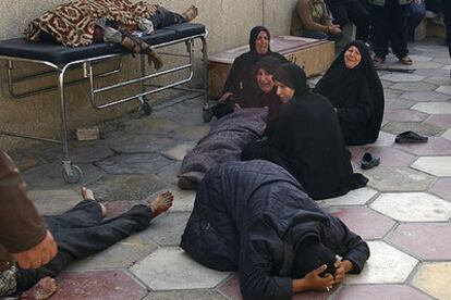 Mujeres iraquíes lloran junto a los cuerpos de algunas víctimas del atentado contra la mezquita de Al Taz.