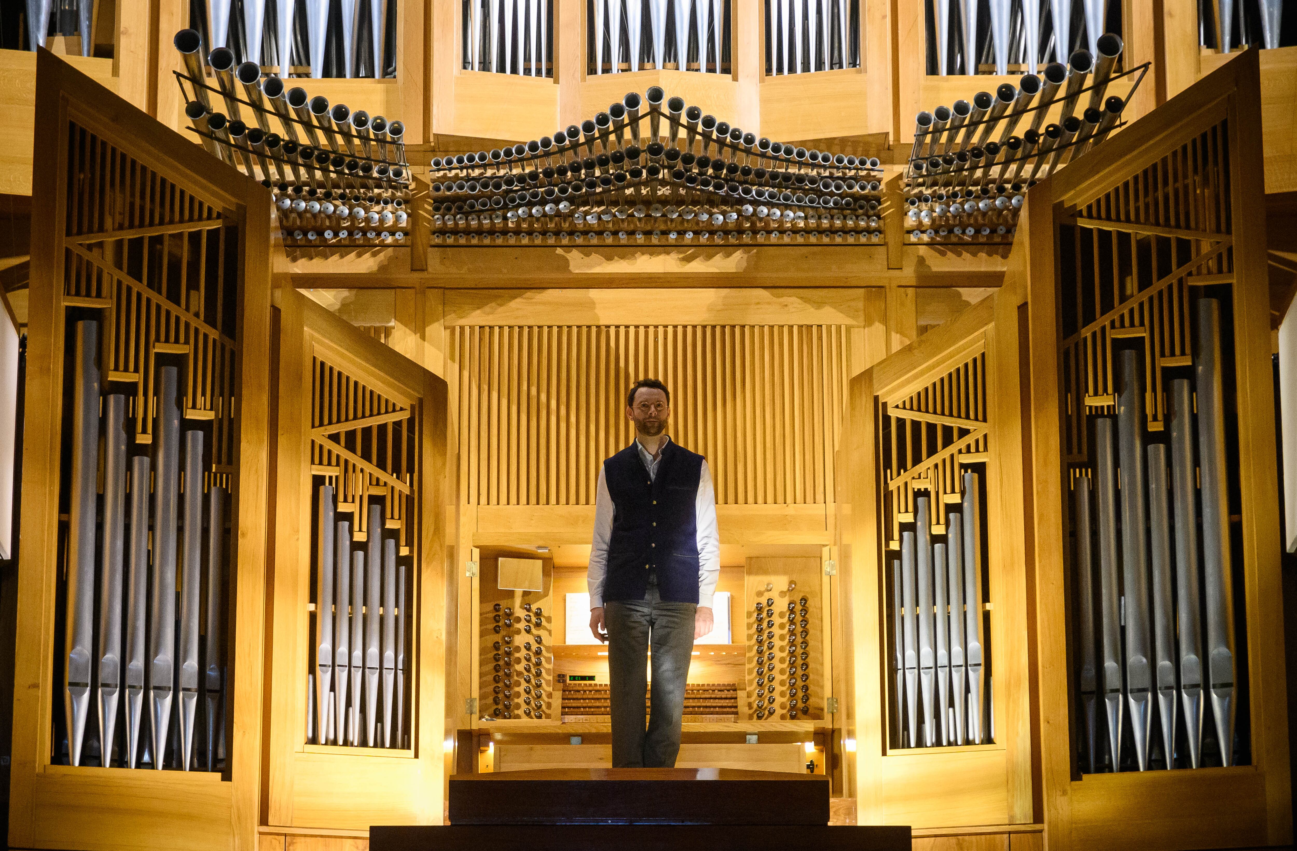 Benjamin Alard agradece desde la galería del órgano los aplausos del público al final de su concierto matinal del sábado.