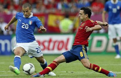 Xavi pelea un balón con Giovinco.