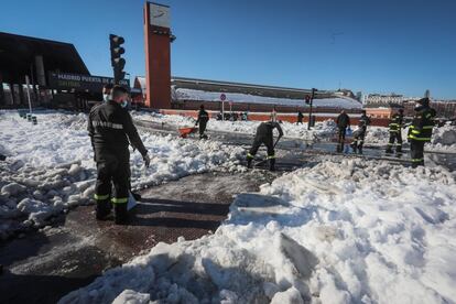 Militares de la UME realizan labores de limpieza para retirar la nieve en la Estación Puerta de Atocha, en Madrid, este lunes.