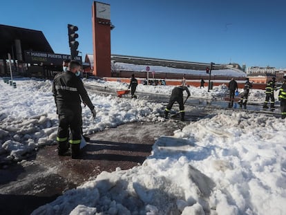 Militares de la UME realizan labores de limpieza para retirar la nieve en la estación Puerta de Atocha, en Madrid, este lunes.