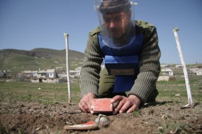 Un empleado de HALO manipula con cuidado munición procedente de una bomba de racimo