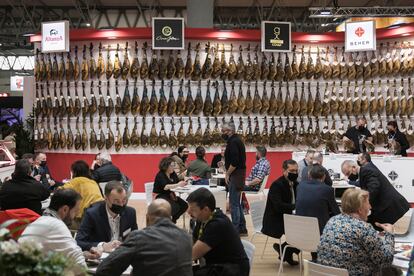 Uno de los expositores de Alimentaria con decenas de jamones en una de sus paredes