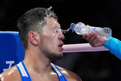 El boxeador Aibek Oralbay de Kazajstán es rociado con agua en una ronda contra el nigeriano Olaitan Olaore, durante la preliminar masculina de 92 kg, el 28 de julio. 