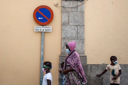 Una mujer con sus hijos salen de paseo de la casa familiar de Cruz Blanca en la calle García Tello.