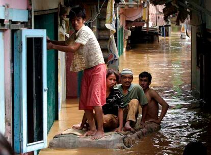 Ciudadanos indonesios tratan de abrirse paso sobre una balsa improvisada a través de una calle inundada en Yakarta. Hasta el momento la inundación se ha cobrado le vida de almenos 29 personas.