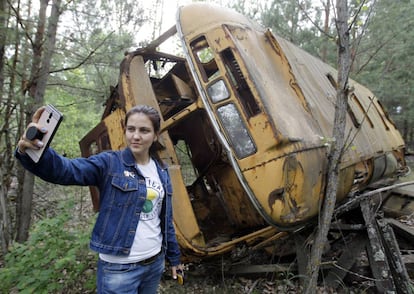 Una turista se hace un selfi frente a un autobús abandonado en Prípiat, Ucrania, este verano.