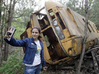 Una turista se hace un selfi frente a un autobús abandonado en Prípiat, Ucrania, este verano.