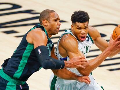 Giannis Antetokounmpo intenta superar a Al Horford. EFE