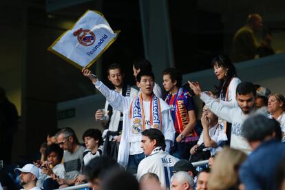 Aficionados madridistas celebran la salida de su equipo al terreno de juego.