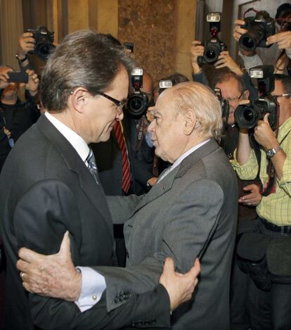 El líder de CiU, Artur Mas, recibe la felicitación del expresidente Jordi Pujol, tras haber sido reelegido presidente de la Generalitat de Cataluña gracias a los votos de CiU y de ERC, en el pleno del Parlament.