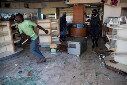 La ola de protestas ha derivado en graves incidentes violentos, con quema y saqueo de comercios y también ataques contra una cadena de televisión y contra la sede de un tribunal local. En la imagen, los policías intentan impedir el saqueo de una tienda durante una protesta el lunes 11 de febrero en Puerto Príncipe (Haití).