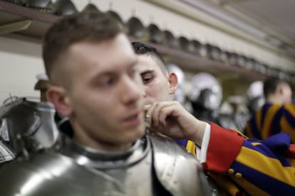 Un miembro de la Guardia Suiza abrocha parte de la armadura de un compañero antes de la ceremonia de juramento en el Vaticano.