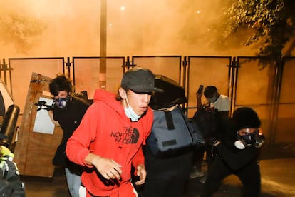 Demonstrators back away from tear gas during a Black Lives Matter protest