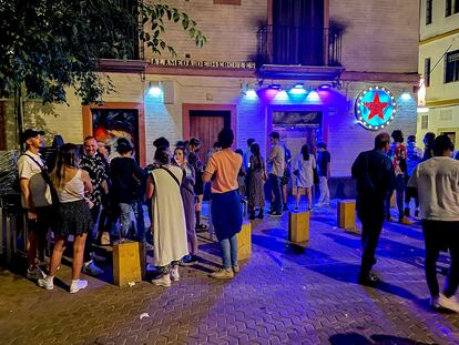 People wait in line outside a nightclub in Seville.