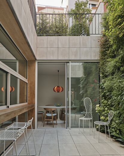 En Barcelona, el estudio Vilablanch transformó un patio. Dejó de ser un lugar de paso para convertirse en el pulmón de la casa. A él se abren hoy el salón, el comedor y la cocina. Así, el soleamiento y la ventilación atraviesan toda la casa. Los taburetes junto a la barra son de Hay. Al fondo, el comedor está amueblado con la mesa Tulip de Eero Saarinen que produce Knoll y la lámpara Disa diseñada por José Antonio Coderch.