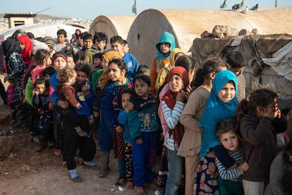 Niños refugiados sirios hacen cola para recibir alimentos en un campamento en la provincia de Idlib.