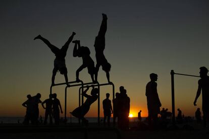 Varios ciudadanos hacen gimnasia en la playa de la Victoria de Cádiz este lunes.