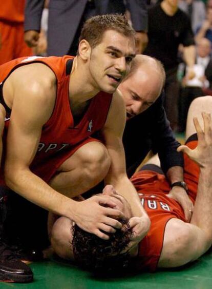 El jugador español de los Raptors de Toronto José Calderón sostiene a su compañero de equipo, Jorge Garbajosa, después de que se resintiera de su pierna izquierda durante los últimos minutos del partido.