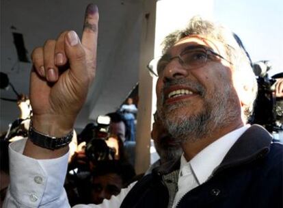 El ex obispo Fernando Lugo, favorito en las encuestas, enseña su dedo manchado de tinta poco después de votar