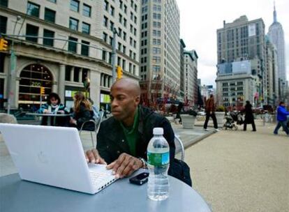 Estudiantes y transeúntes comparten espacio en una plaza peatonal en el centro de Manhattan, en Nueva York. Al fondo, el Empire State Building.