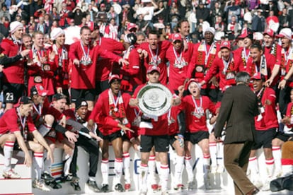 El jugador del PSV Phillip Cocu, en el centro, sostiene el trofeo de la Liga holandesa, el 19º que logra su equipo.