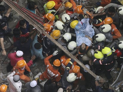 Rescatistas sacan a una sobreviviente de un edificio en Bombay (India).