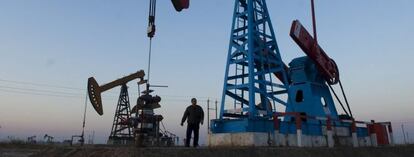 Imagen de archivo de un trabajador bajo un pozo de petr&oacute;leo