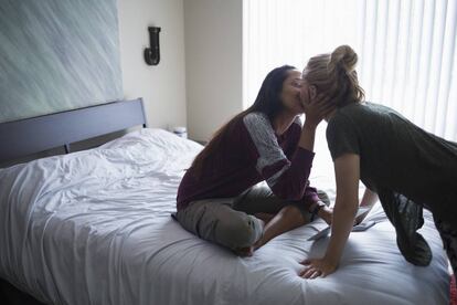 Dos mujeres se besan en una habitaci&oacute;n de hotel