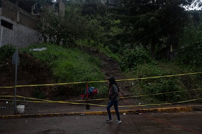 Una niña pasa frente la zona acordonada donde ocurrió el deslave.