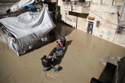 Unos niños disfrutan de un paseo en bote a lo largo de una calle inundada en la ciudad de Darkush, en el oeste de la provincia de Idlib (Siria). 