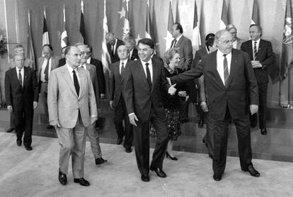 El canciller alemán Helmut Kohl coge del brazo al presidente del Gobierno, Felipe González, en presencia del presidente francés, François Mitterrand, tras la foto de familia del Consejo Europeo reunido en Madrid bajo la presidencia española de la Comunidad Europea, en el que se decidió la unión monetaria.
