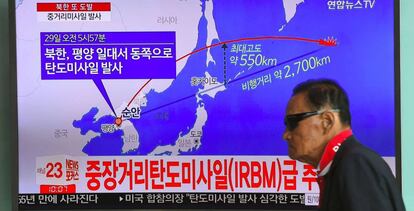 Un home sud-coreà davant una pantalla de televisió que mostra la trajectòria recorreguda pel míssil nord-coreà.