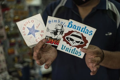 Un vendedor sostiene imágenes de las pandillas más populares de Monterrey: Símbolo Star, Símbolo Uno y Bandas Unidas. Las fiestas de cumbia terminan constantemente con peleas de estas pandillas.