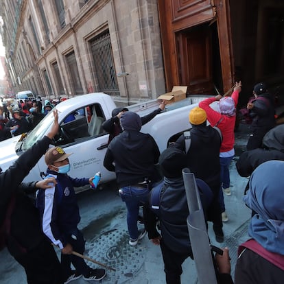 MEX952. CIUDAD DE MÉXICO (MÉXICO), 06/03/2024.- Manifestantes encapuchados vandalizan una de las puertas del Palacio Nacional este miércoles, en Ciudad de México (México). Jóvenes mexicanos que protestan por la desaparición de los 43 estudiantes de Ayotzinapa rompieron este miércoles una de las puertas principales del Palacio Nacional mientras el presidente, Andrés Manuel López Obrador, realizaba adentro su conferencia matutina. Los manifestantes, quienes acusan a López Obrador de no resolver el caso para proteger a militares involucrados, tomaron una camioneta que pertenece a la Comisión Federal de Electricidad (CFE) para tumbar la puerta 1 sobre la calle Moneda del centro histórico de Ciudad de México. EFE/ Madla Hartz