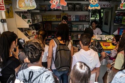 Varios adolescentes hacen cola en una firma de libros en una de las casetas el día de la inauguración de la Feria del Libro de Madrid, en el parque del Retiro, en 2022.