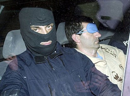Iñaki Lizundia, a la derecha, con los ojos tapados, es trasladado tras su detención en un vehículo de la Gendarmería.