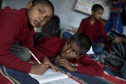 Dos niños completan sus deberes en una escuela en la India.