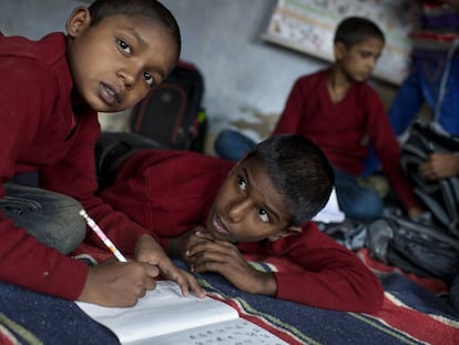 Dos niños completan sus deberes en una escuela en la India.