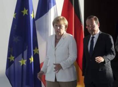 La canciller alemana Angela Merkel conversa con el presidente de Francia, François Hollande, antes de ofrecer una rueda de prensa en la cancillería de Berlín, Alemania, el pasado 23 de agosto del 2012.