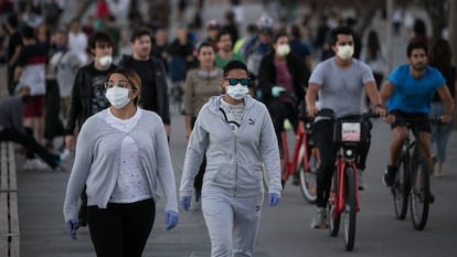 People walk and cycle along the seaside promenade in Barcelona on Sunday.