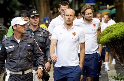 O holandês Robben caminha ao lado de um policial no Rio de Janeiro.