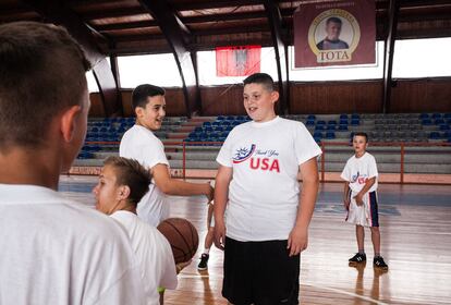 Un equipo de baloncesto infantil juega un torneo amistoso con una camiseta en la que se lee: “Gracias, Estados Unidos”.
