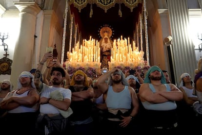 Los costaleros de María Santísima de Fe observan la salida del paso de la Santa Cena en Almería, el 25 de marzo.