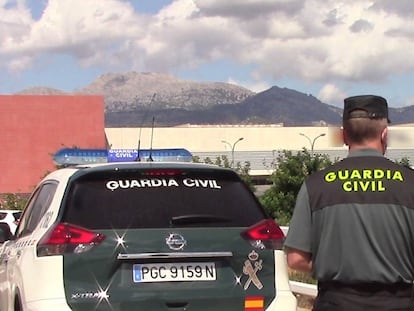 Un vehículo de la Guardia Civil y un agente de espaldas