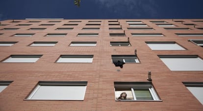 Una vecina se asoma a la ventana en un edificio del Ensanche de Vallecas que el Ivima quiere incluir en un fondo.