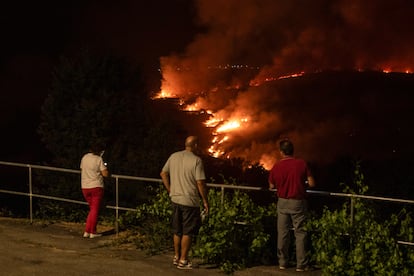 Varias personas observan el incendio de Oímbra (Ourense) la pasada noche.