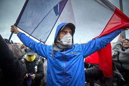 Un manifestante sujeta una bandera francesa durante las protestas en el centro de París en el primer aniversario de los 'chalecos amarillos'.