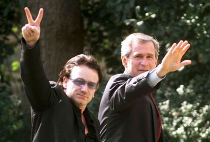 Bono hace el signo de la victoria junto a George Bush tras una reunión en febrero de 2002 del Banco Interamericano de Desarrollo en la Casa Blanca sobre la deuda del Tercer Mundo.
